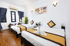 A hotel room with two beds, a potted plant, and artwork on the wall. - Casablanca Hotel (Hue)