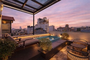 A rooftop terrace with a pool, seating areas, and a view of the city skyline. - Golden Rice Hotel (Hanoi)
