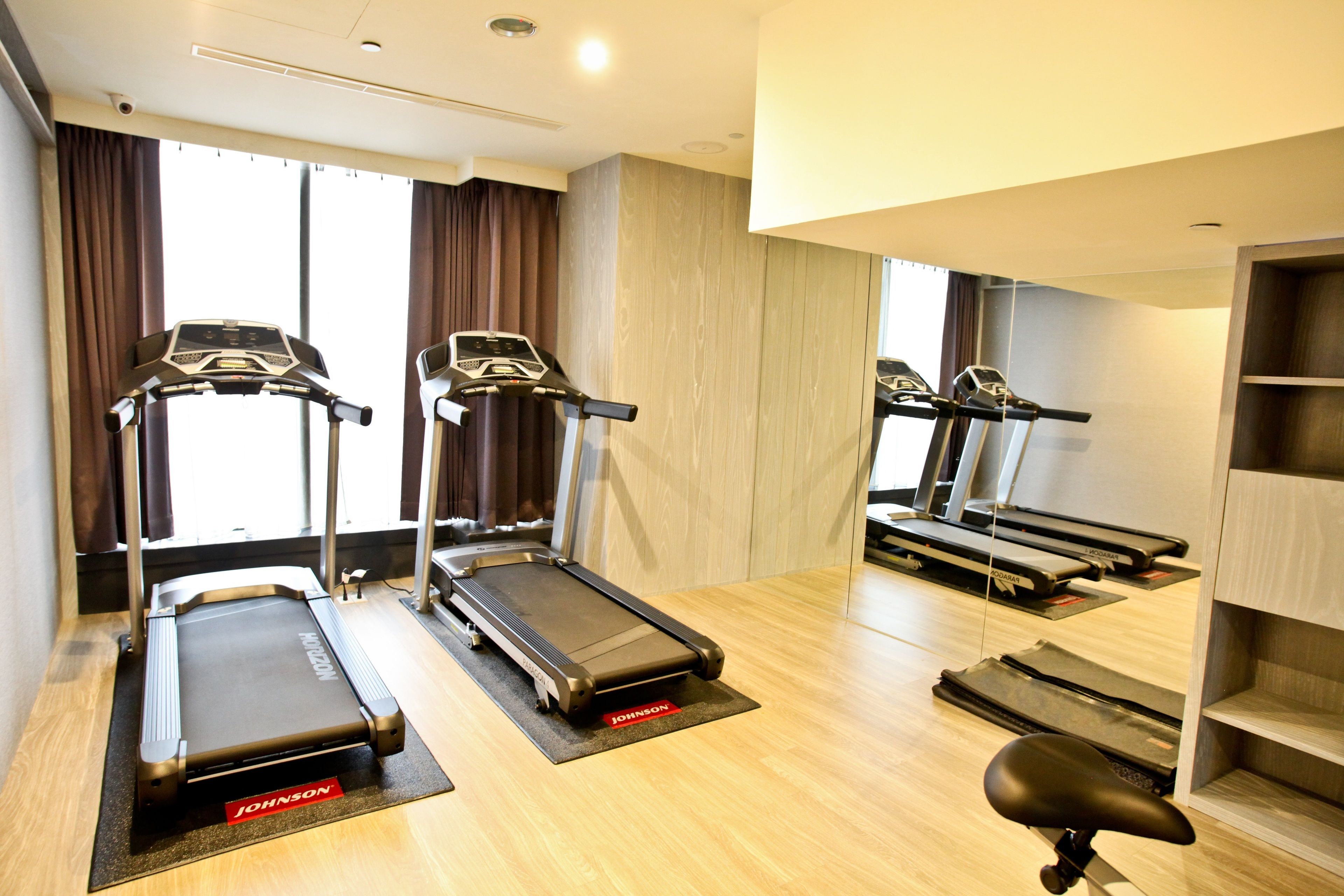 A fitness room with treadmills, a stationary bike, and a rowing machine.