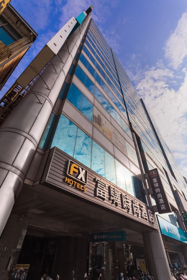 A hotel building with a prominent FX logo, large glass windows, and a modern architectural design. - FX Hotel Tainan MinSheng Road Branch (Tainan)