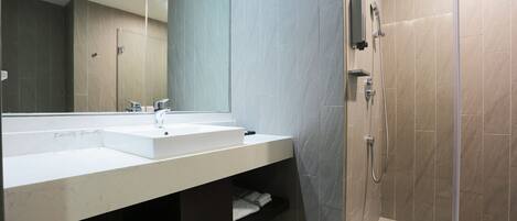 A modern bathroom with a large mirror, two sinks, a shower, and a towel rack.