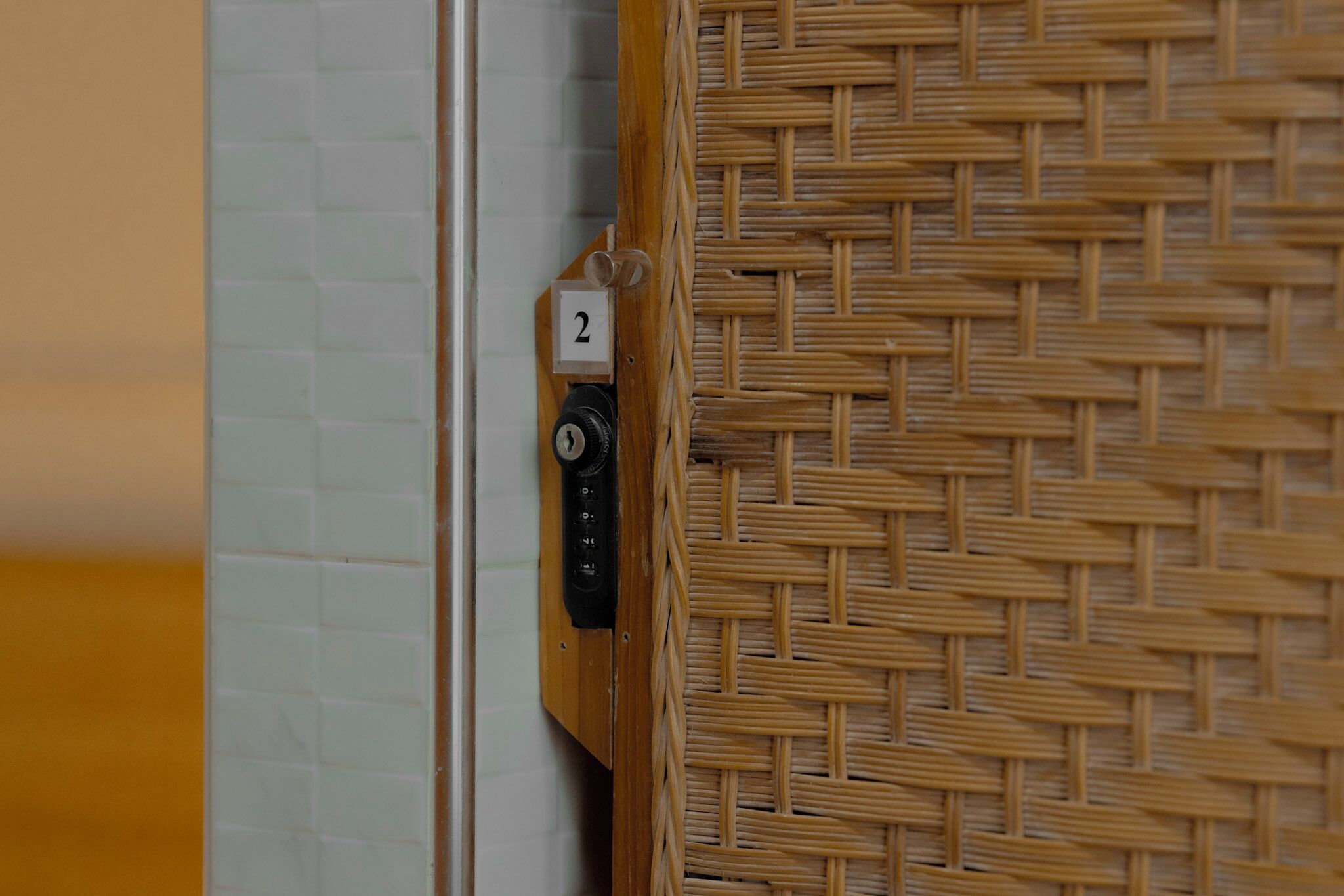 A door with a woven mat and a numeric keypad lock.