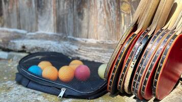 A collection of colorful balls and wooden sticks on a stone surface with a wooden background.
