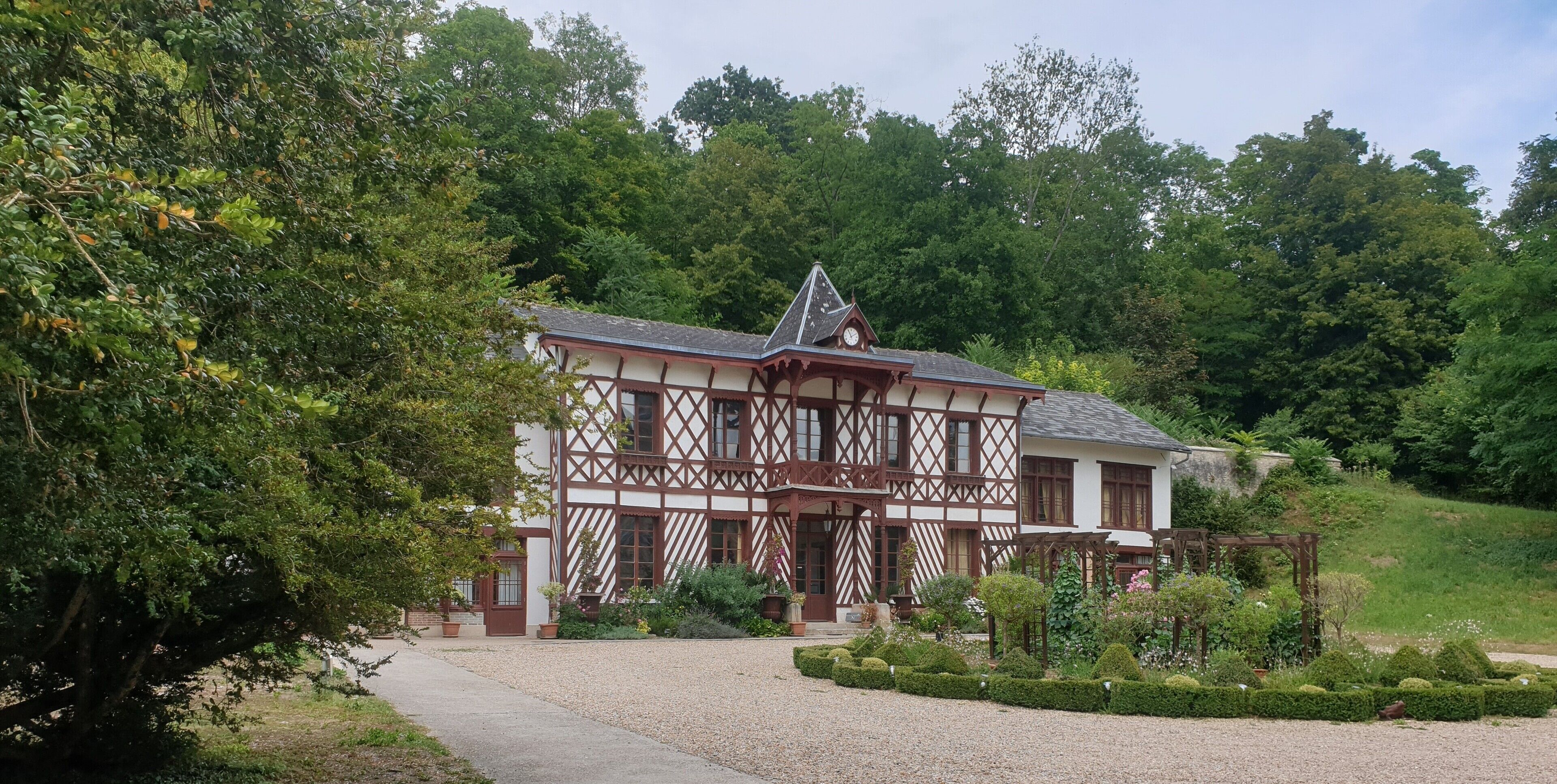 Ein traditionelles Fachwerkhäuschen mit einem Schotterweg und einem gepflegten Garten.