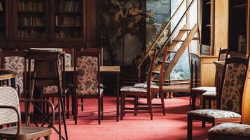 A library with wooden bookshelves, a red carpet, and a staircase.
