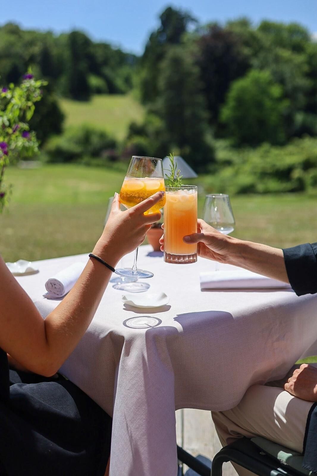 Ein Tisch im Freien mit Tischdecke, zwei Orangensaftgläsern und einem zusammengerollten Handtuch.