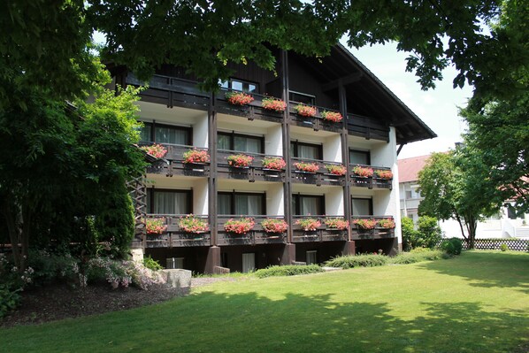 A multi-story hotel with balconies adorned with flower boxes. - Hotel garni Bellevue (Bad Fuessing)