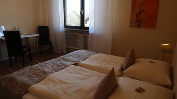 Ein Hotelzimmer mit zwei Betten, einem Schreibtisch und einem Stuhl.