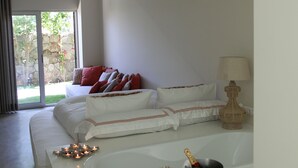 Un dormitorio con cama, una mesita de noche con lámpara y vistas al exterior.