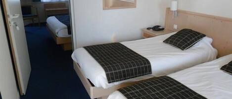 Habitación de hotel con dos camas, un escritorio, una silla, un televisor y un espejo.