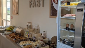 A breakfast buffet with various pastries, bread, and condiments. - Hotel L'Océane Angers Parc Expo (Rives-du-Loir-en-Anjou)