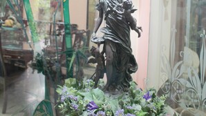 A statue of a woman holding a child, surrounded by decorative plants and a bamboo backdrop. - Lahore Guest House (Lahore)