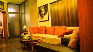 A living room with a sofa, a glass coffee table, and a lamp. - Lahore Guest House (Lahore)