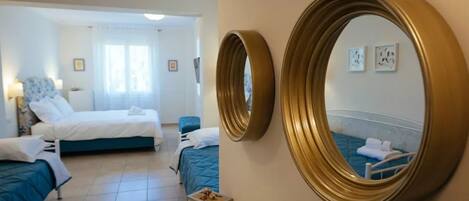 A hotel room with two beds, a large mirror, and a small bedside table.