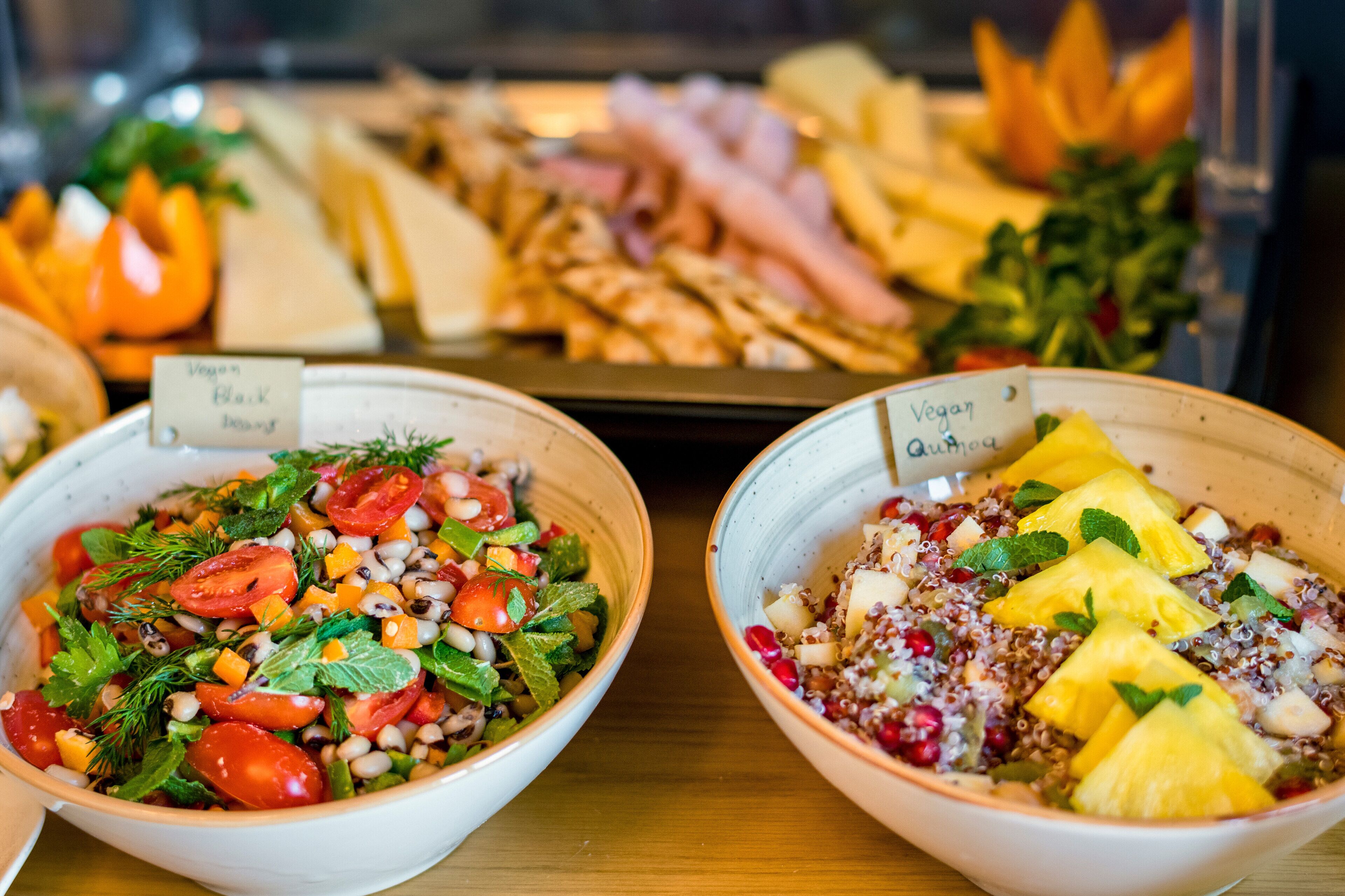 Deux saladiers remplis de salade, chacun portant une étiquette indiquant qu’il s’agit d’une salade végétalienne.
