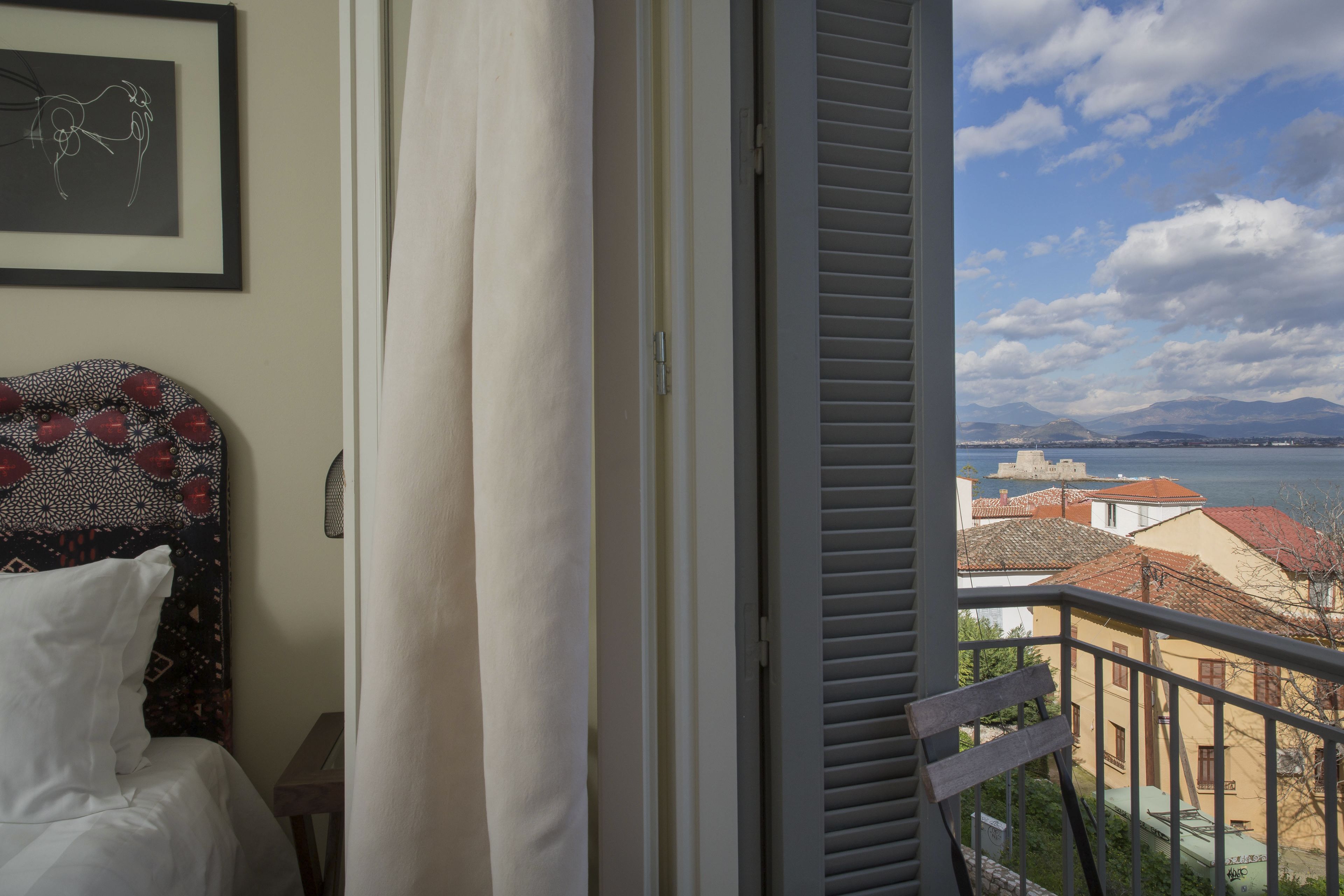 A balcony with a view of a coastal town and mountains.