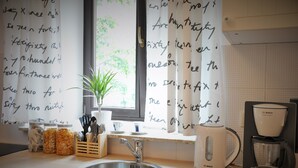 A kitchen with a sink, a Bosch coffee maker, and jars of food on the counter. - HappyGuests Apartments (Kraków)