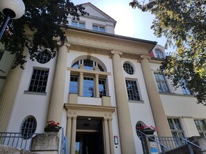A classical building with a symmetrical facade, large windows, and a central entrance with columns. - Hotel Villa Heine (Halberstadt)