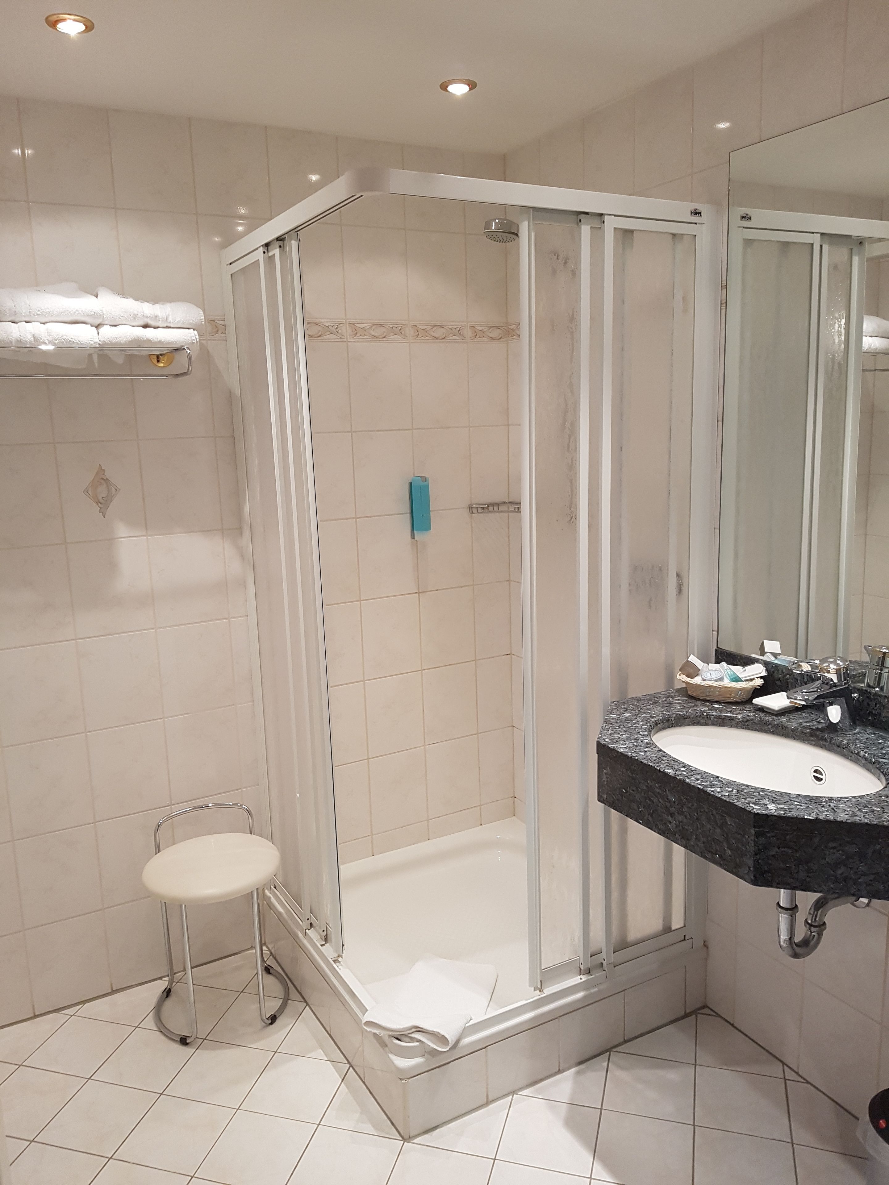 Ein modernes Badezimmer mit einer Duschkabine aus Glas, einer weißen Toilette und einem Waschbecken mit schwarzer Arbeitsplatte.