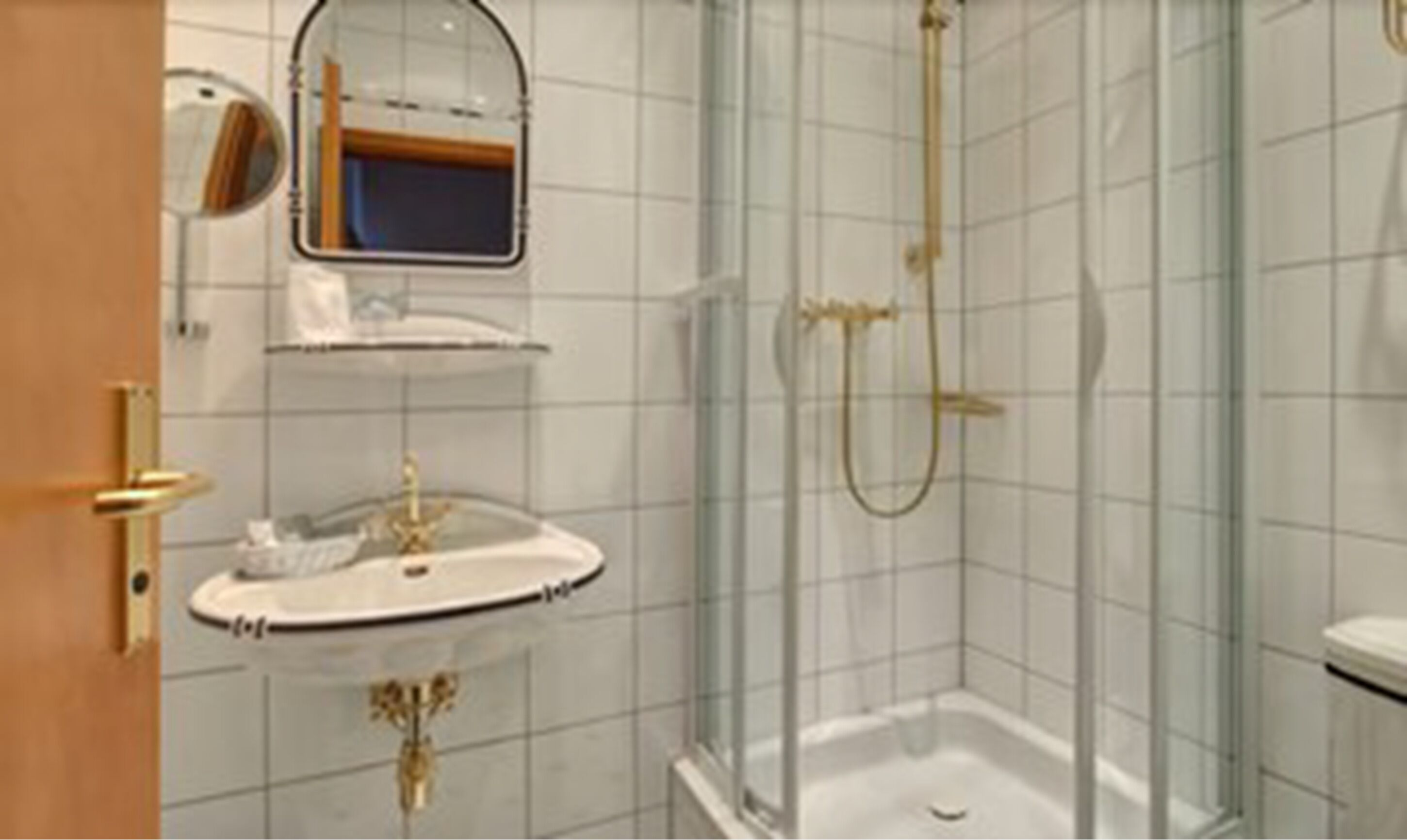 A bathroom with a sink, mirror, and shower.