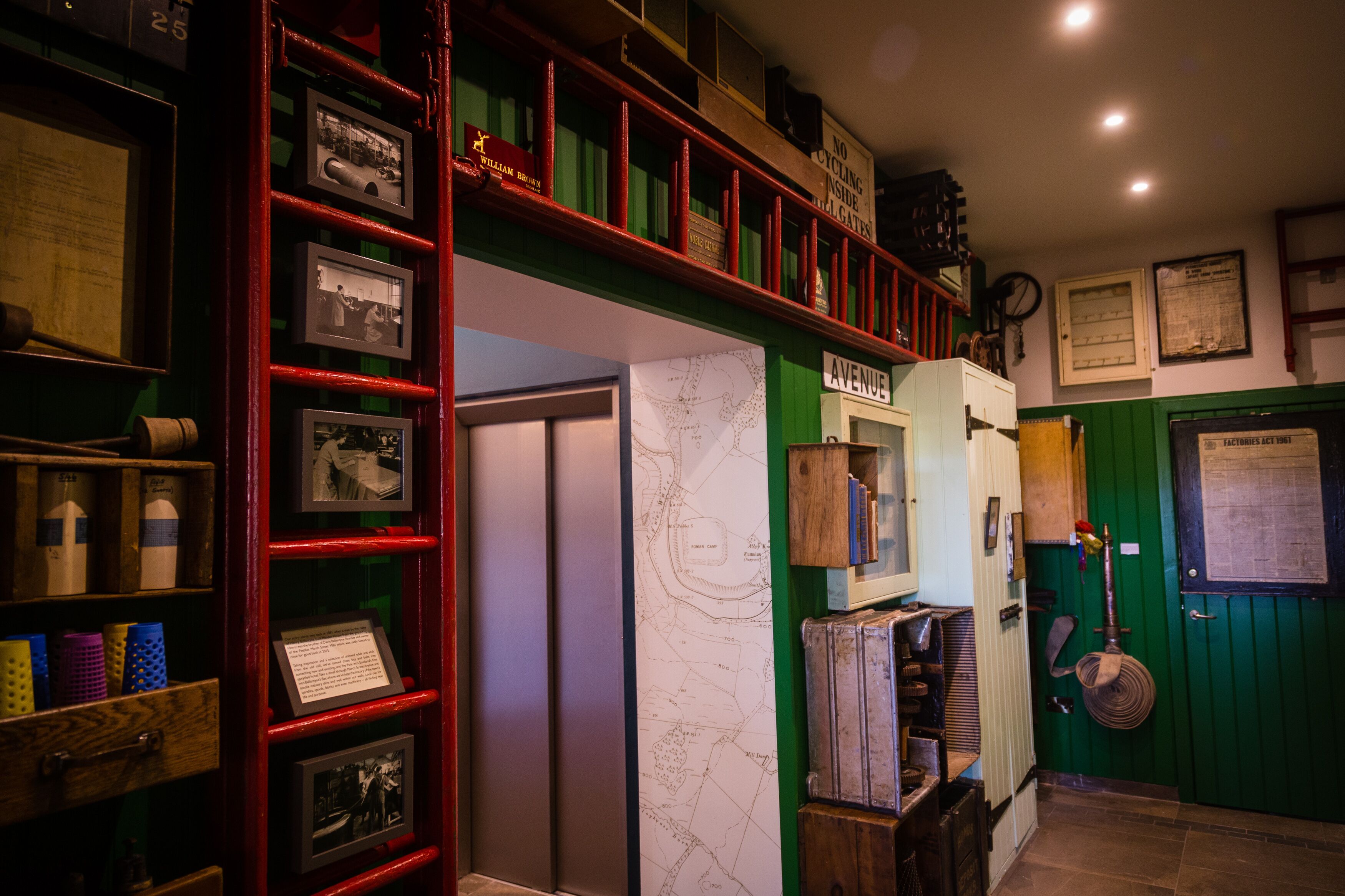 A room with a map on the wall, a red ladder, and various items on shelves.