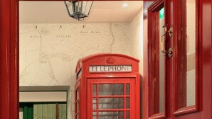A red telephone booth and a red door in a hallway with a map on the wall. - The Park Hotel Peebles (Peebles)