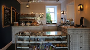 A bakery counter with baked goods, a coffee machine, and a menu board. - The Park Hotel Peebles (Peebles)