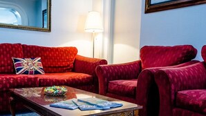 A room with a red velvet sofa set, a glass coffee table, and a lamp. - The Avenue (Shanklin)