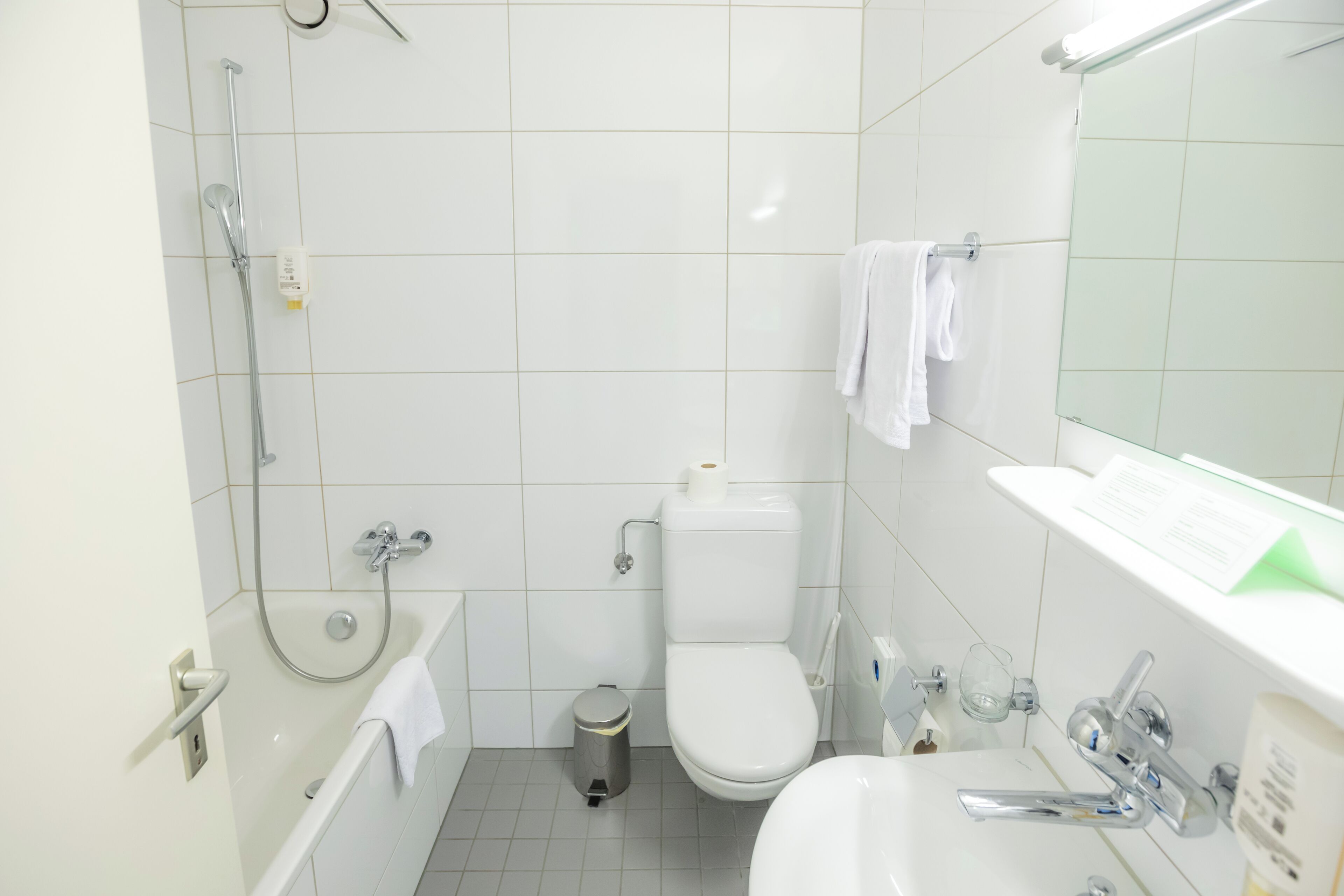 Een moderne badkamer met een bad, toilet en wastafel.