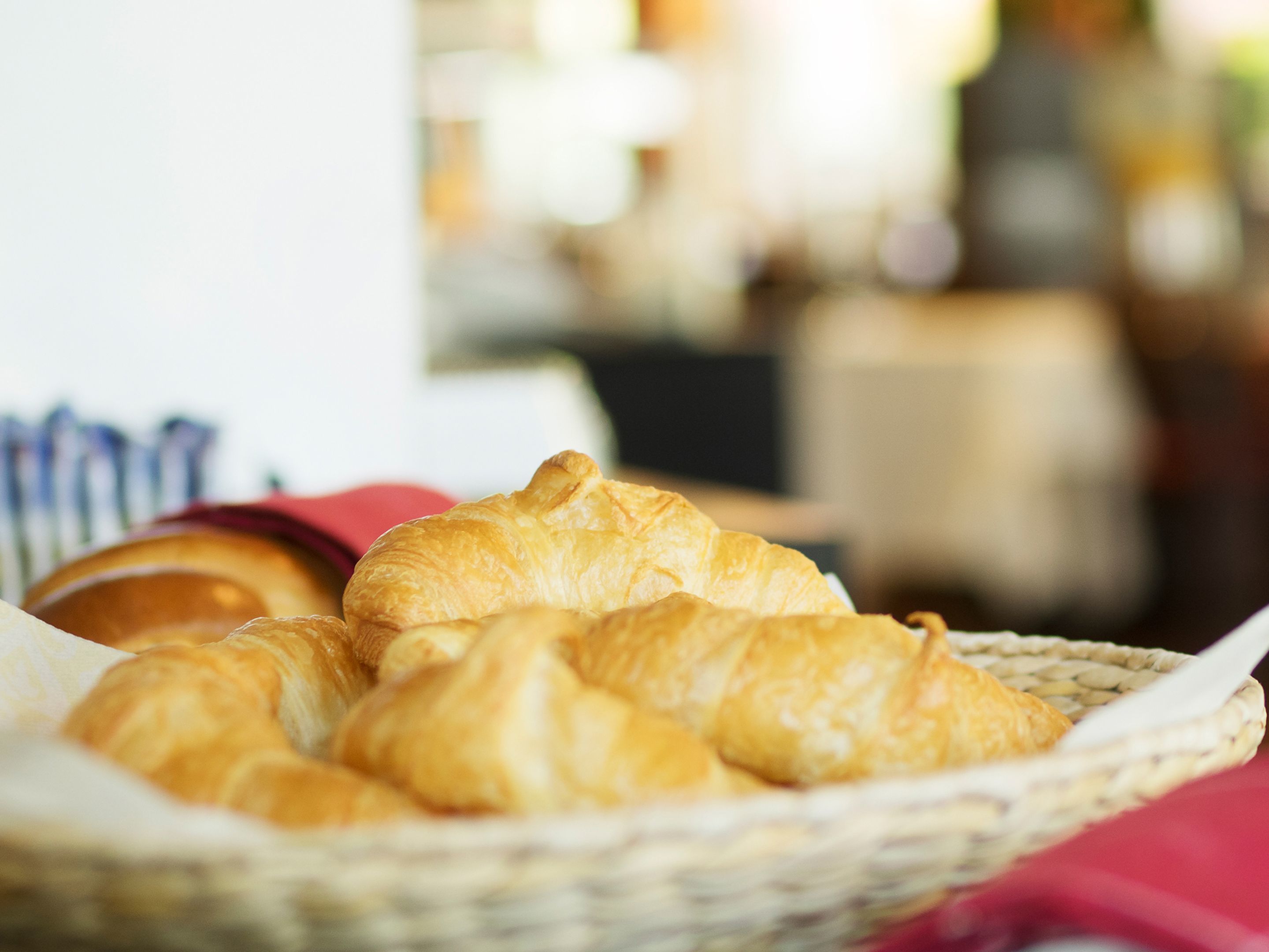 Ein Korb mit Croissants auf einem Tisch.