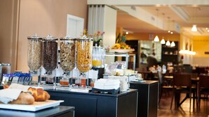 Un comptoir de petit-déjeuner avec divers distributeurs de nourriture, un croissant et une machine à café.