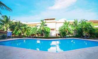 Una piscina al aire libre, sillones reclinables de piscina