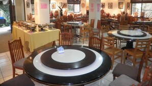 A restaurant with multiple round tables and chairs, a buffet setup, and various wall decorations. - Xitou Education Center Hostel (Lugu)