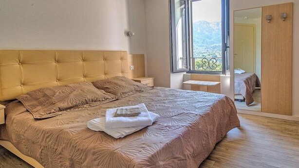 Una camera da letto con un letto grande, un comodino, una finestra vista e un armadio.