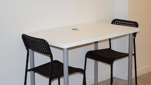 A small, white table with two black chairs. - Detroit Vacation Rental (Hamtramck)