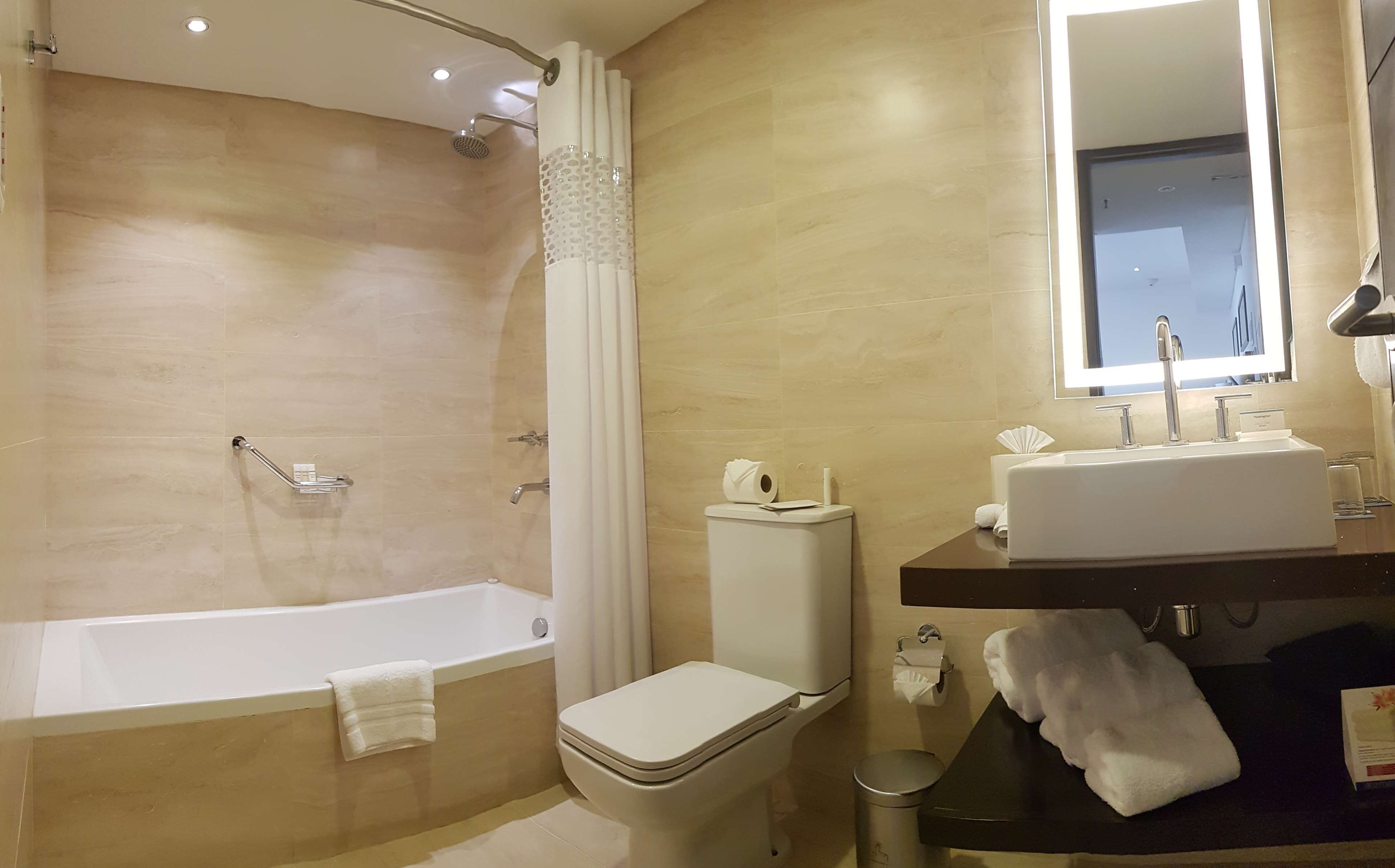 A modern bathroom with a bathtub, toilet, and sink.
