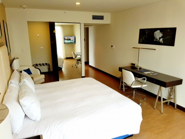 A hotel room with a large bed, a desk, a chair, a TV, and a picture on the wall. - Hampton by Hilton Santa Cruz/Equipetrol, Bolivia (Santa Cruz)