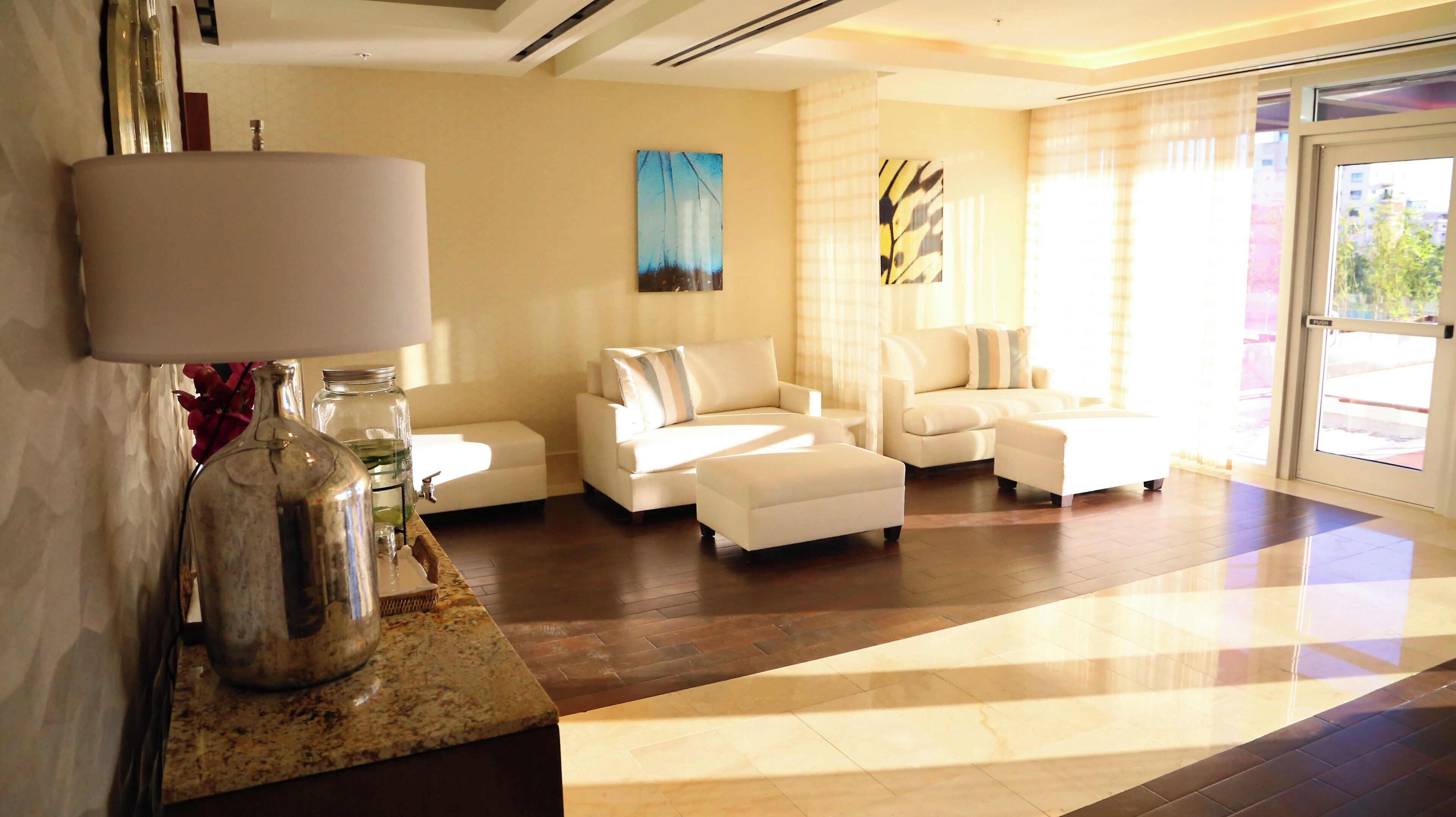 A modern living room with a sofa set, a coffee table, and a lamp.