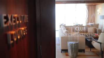 Vista del Executive Lounge, con una decoración moderna que incluye un sofá, sillones y una mesa de centro.
