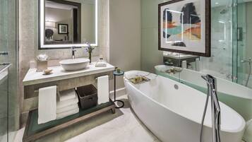 A modern bathroom with a freestanding bathtub, a large mirror, and a glass-enclosed shower area.