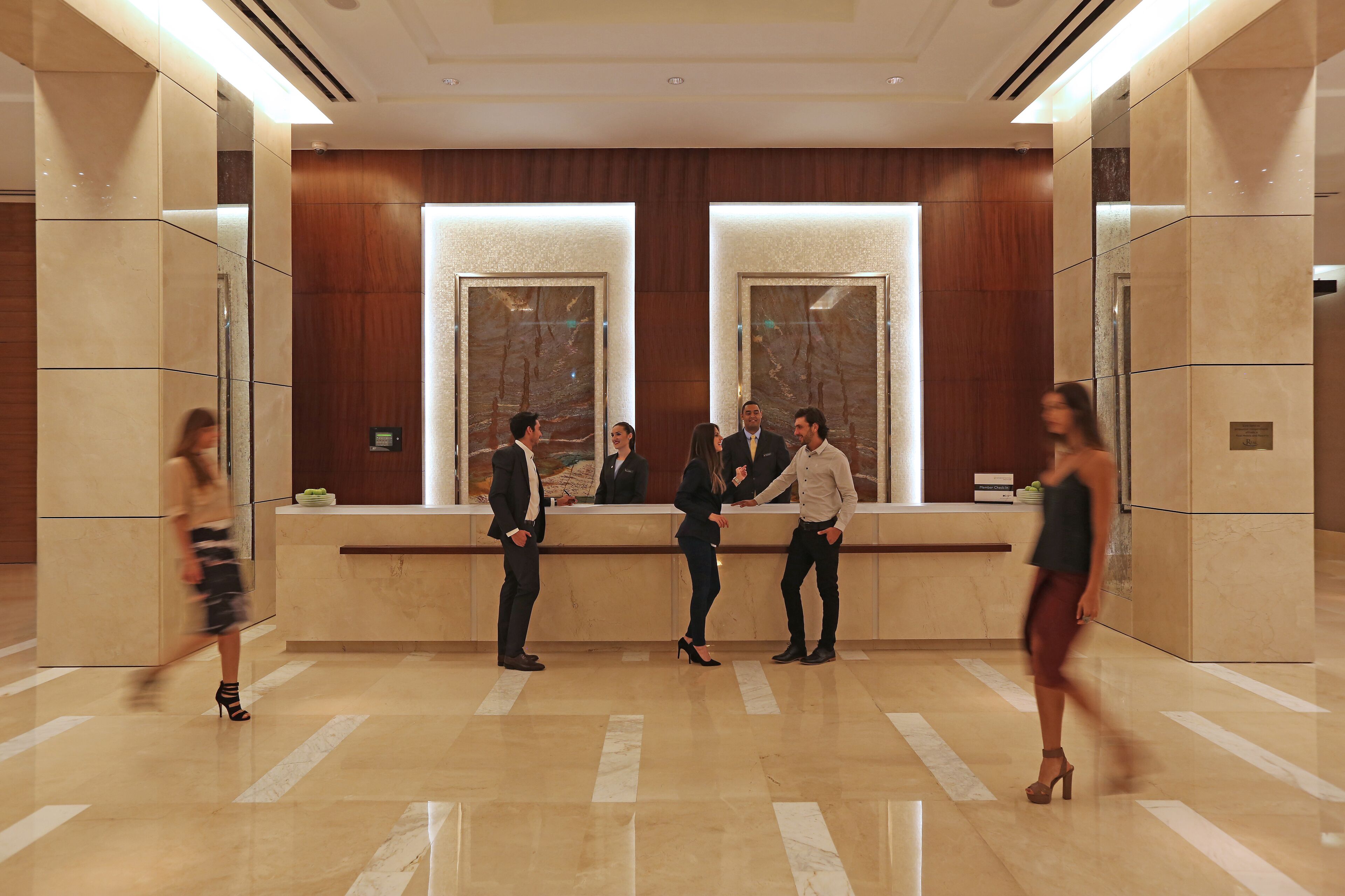 Eine Lobby mit Empfangstresen, Marmorböden und Holzvertäfelung.