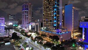 A high-rise hotel with multiple floors, illuminated windows, and a rooftop bar.