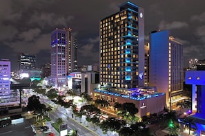 Un hôtel de grande hauteur, avec de nombreux étages, des fenêtres illuminées et un bar situé sur le toit.