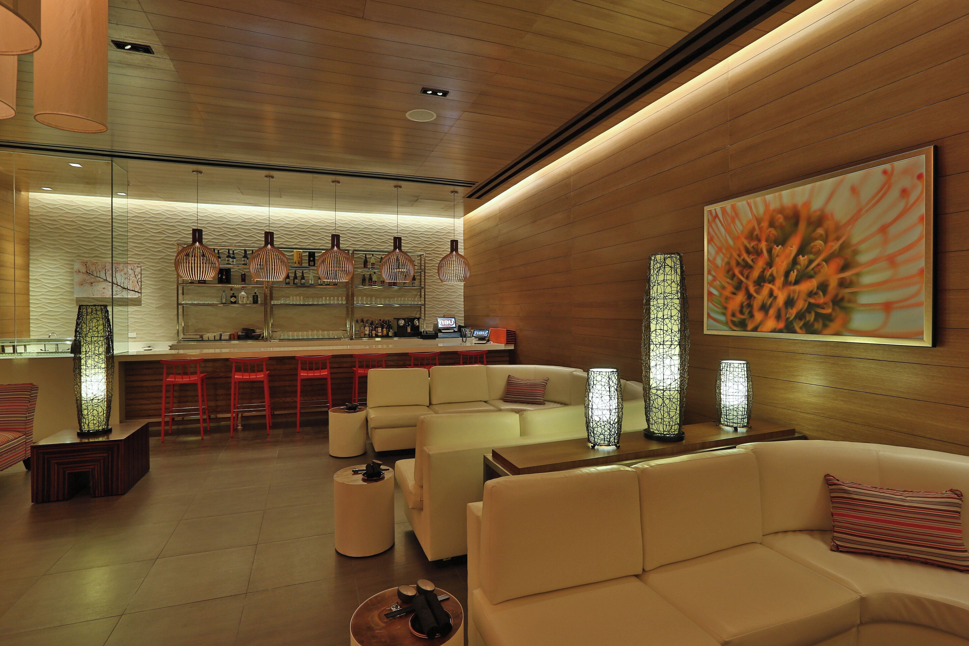 A modern interior with a bar area, seating, and decorative lighting.