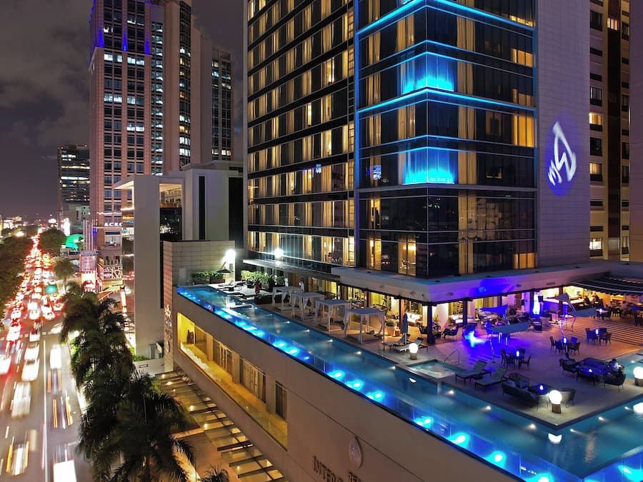 Una piscina al aire libre, sombrillas, sillones reclinables de piscina