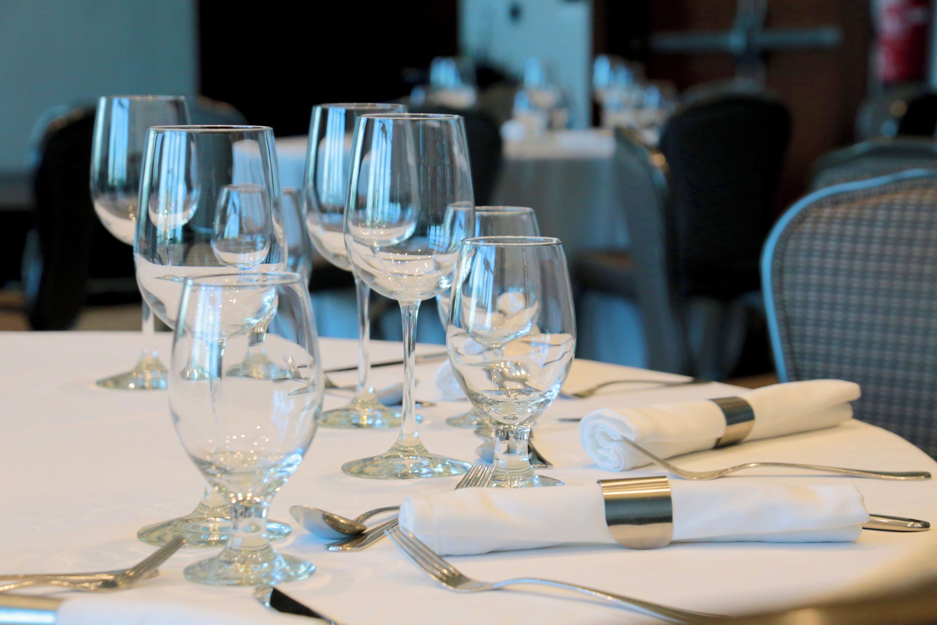 A table set with multiple wine glasses and cutlery, indicating a dining setup.