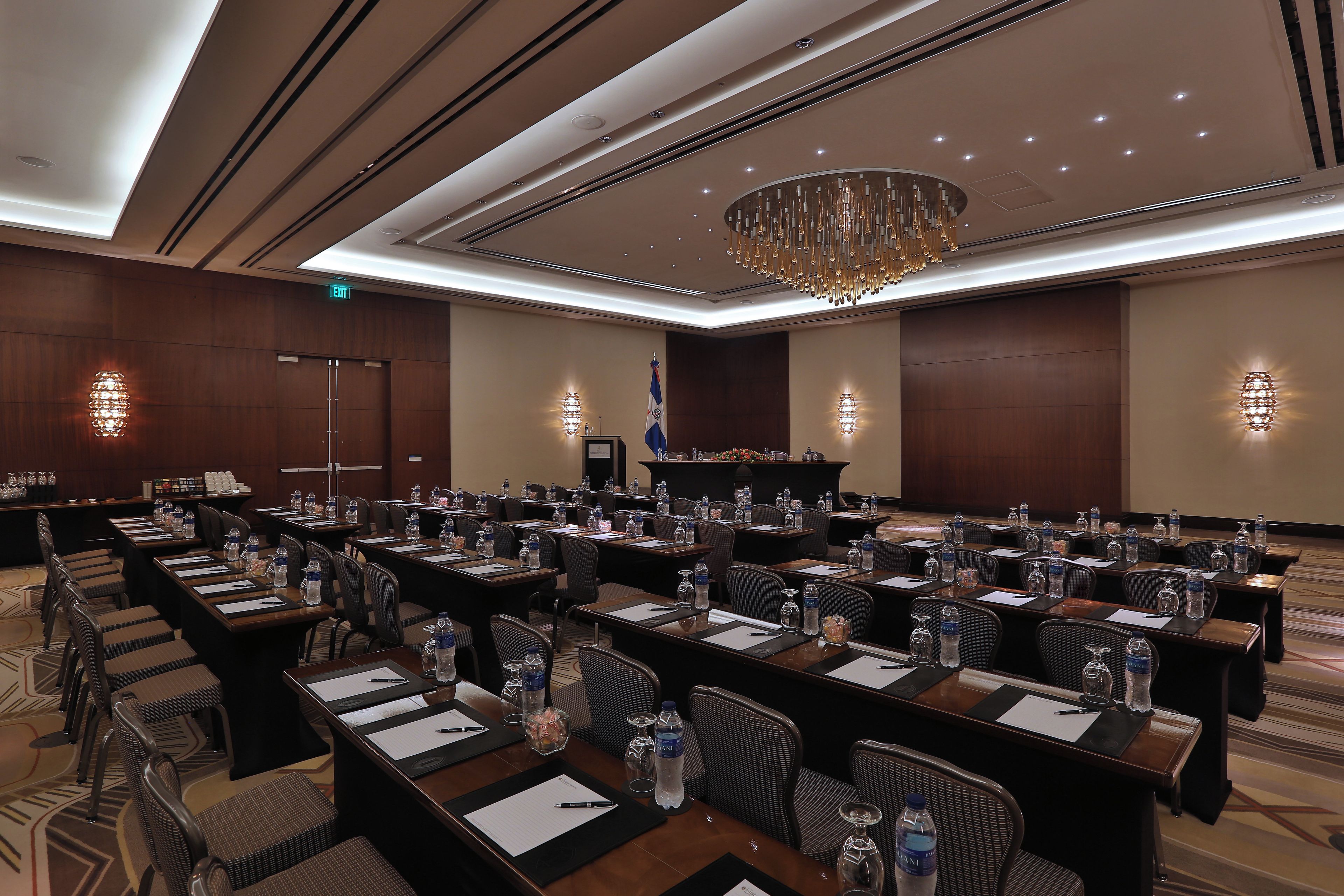A conference room with multiple tables, chairs, and a podium.