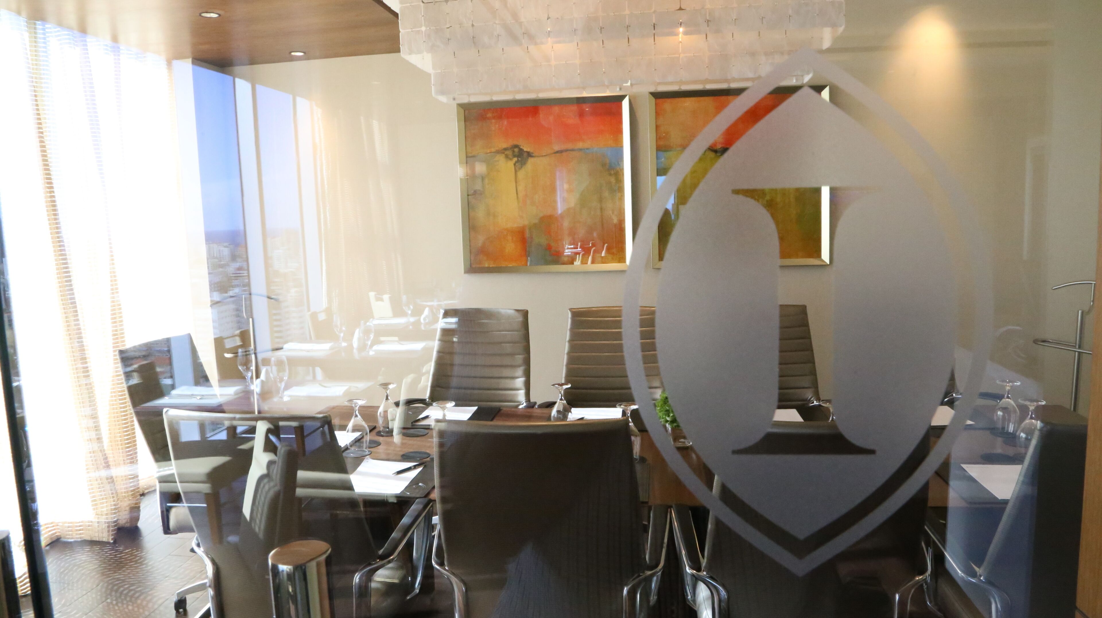 Une chambre d’hôtel moderne dotée d’une grande fenêtre, d’un coin repas avec des chaises et une table, et d’un tableau accroché au mur.