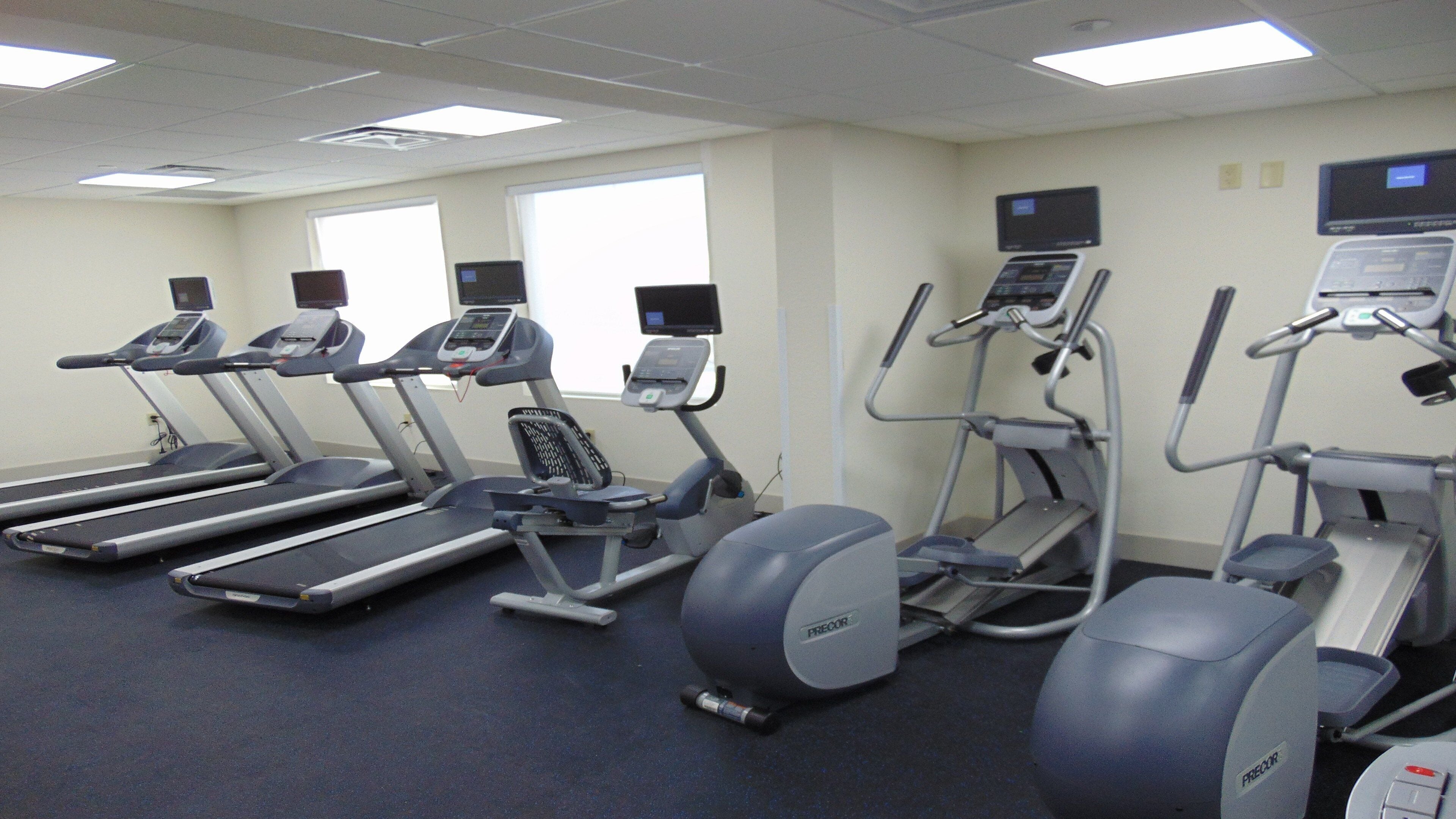 Una palestra attrezzata con tapis roulant, ellittiche e una cyclette.