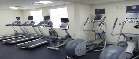 Una palestra attrezzata con tapis roulant, ellittiche e una cyclette.